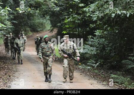 Le capitaine de l'armée américaine Calvin L. Amaranta, droite, commandant d'une compagnie, 1er bataillon du 327e Régiment d'infanterie, 101st Airborne Division (Air Assault), suit le rythme avec la Marine nationale gabonaise 1er lieutenant Zengue Boucah Pierre Cedric Marvin, sur un terrain de marche à travers une forêt tropicale warfare training center à Libreville au Gabon, le 26 juillet 2017. La formation dispensée a fait partie de la nation partenaire judicieux exercice 'Activation 17-2. Banque D'Images