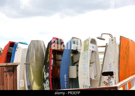 Dingy,s en différentes couleurs empilés verticalement sur une ligne Leigh on Sea, Essex Banque D'Images