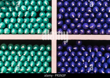 Couleur multicolore vert et bleu bâton paraffine des bougies disposées sur des étagères dans un magasin Banque D'Images