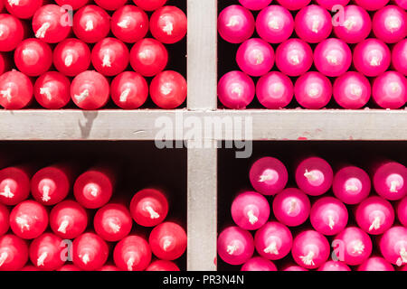 Couleur multicolore rouge et rose stick paraffine des bougies disposées sur des étagères dans un magasin Banque D'Images