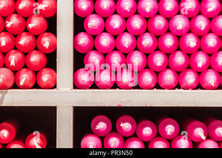 Couleur multicolore rouge et rose stick paraffine des bougies disposées sur des étagères dans un magasin Banque D'Images