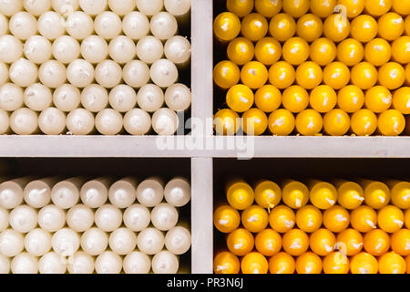 Blanc et jaune stick de paraffine des bougies disposées sur des étagères dans un magasin Banque D'Images