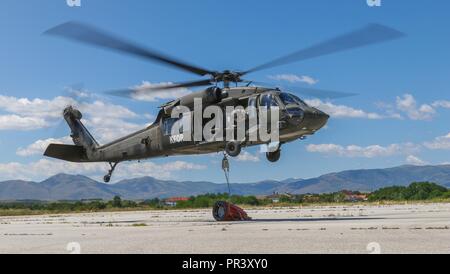 Un UH-60 Black Hawk à l'essai par des soldats du 1er bataillon du 185e Régiment d'aviation de Tupelo, Mississippi lift off avec un seau d'eau attaché pendant que l'eau et formation certificationJuly godet 28, 2017 à Gjakova aérodrome. Banque D'Images