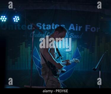 Navigant de première classe Josiah Joyce, guitariste pour Starlifter, U.S. Air Forces Central Command Band, exécute pour le 380e Escadre expéditionnaire de la Marine le 26 juillet 2017, à la base aérienne d'Al Dhafra, aux Émirats arabes unis. L'AFCENT Band, stationné à Al Udeid Air Base, Qatar, parcourt la zone de responsabilité du commandement central à l'appui de la création de partenariats, de remonter le moral, et en fournissant la diplomatie et la sensibilisation des collectivités du pays hôte. Banque D'Images