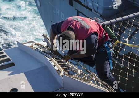 BRISBANE, AUSTRALIE (29 juillet 2017) l'Aviation maître de Manœuvre (manutention) Airman Rinaldy Desulme, de West Palm Beach, en Floride, se prépare à lever un filet de sécurité sur le côté tribord de l'élévateur de l'avion d'assaut amphibie USS Bonhomme Richard (DG 6) que le navire arrive à Brisbane. Bonhomme Richard, navire amiral du Bonhomme Richard Expeditionary Strike Group (ESG), est prévue à Brisbane pour une visite du port. Au cours de la visite, Bonhomme Richard organise des visites de navires et de l'expérience de la culture de la ville. Banque D'Images