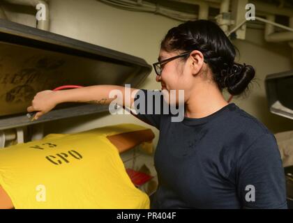 Le Golfe Arabique (30 juillet 2017) La Marine américaine structurels de l'Aviation l'Aviateur Mécanicien Jesni Morales, d'El Paso, Texas, presses blanchisserie à bord du porte-avions USS Nimitz (CVN 68), le 30 juillet 2017, dans le golfe Arabo-Persique. Nimitz est déployée dans la 5e flotte américaine zone d'opérations dans le cadre de l'opération inhérents résoudre. Alors que dans cette région, le navire et d'attaque mènent des opérations de sécurité maritime pour rassurer les alliés et les partenaires, de préserver la liberté de navigation, et de maintenir la libre circulation du commerce. Banque D'Images