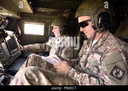 La CPS. Jérémie Schaaff, affecté à la Garde nationale du Colorado et de la CPS. Ryan Dalton, Wyoming, Garde nationale d'armée de se préparer à un incendie simulé la mission dans un système de roquettes d'artillerie à grande mobilité en tant que partie d'un cours de reclassement effectué récemment au Camp Guernesey JTC. Les 16 étudiants, provenant de huit membres sont évalués comme conducteur de l'HIMARS, mais sont formés dans les trois rôles d'équipage. Army National Guard (Wyoming Banque D'Images