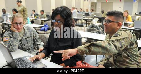 Le Sgt. Alberto Gonzalez, instructeur de l'armée américaine avec l'ESRB réserver la commande G-1 (à droite), aide Pamela Kone, administrateur de l'unité pour la Réserve de l'Armée est 399e Détachement de transport (centre) et Spec. Behringer Miranda, spécialiste en ressources humaines avec la réserve de l'armée des affaires civiles du 432e Bataillon, pendant la gestion électronique des dossiers du personnel et système d'enregistrement automatisé Brève formation organisée par l'armée de réserve 99e Commandement du soutien régional 24-28 août sur Joint Base McGuire-Dix-Lakehurst, New Jersey. Le maintien d'un iPERMS fiche du soldat et ARB peut avoir un impact direct sur readine Banque D'Images