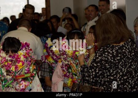 Les enfants de la Sainte Famille Accueil orphelinat à Osaka, Japon recevoir Leis, comme ils sont accueillis à l'iw famille pour les deux semaines à venir à la cérémonie d'accueil tenue à l'Aéroport International Daniel Inouye K. à Honolulu, Hawaii, le 24 juillet 2017. Ceci marque la 60e année de cet échange pour le 27e Régiment d'infanterie et de la Sainte Famille à la maison. Banque D'Images