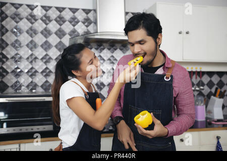 Happy Smiling young couple et la cuisson des aliments dans la cuisine à la maison Banque D'Images