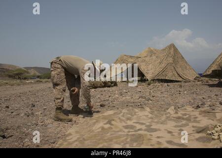 DJIBOUTI-U.S. Le Cpl Marine. Derek Solano, un assaut de affectés au Siège et support compagnie, bataillon de l'équipe d'atterrissage 3/1, 13e Marine Expeditionary Unit (MEU), une bâche de camouflage au cours de théâtre de combat amphibie (Répétition TACR), July 9, 2018. Dirigé par la force, de la Naval Amphibious Task Force 51/5ème Marine Expeditionary Brigade, TACR intègre U.S. Navy Marine Corps et biens pour pratiquer et répéter un éventail de capacités liées à l'combat critiques disponibles pour le Commandement central américain, sur mer comme à terre, à promouvoir la stabilité et la sécurité dans la région. 5e Flotte des États-Unis et de l'actif de la coalition Banque D'Images