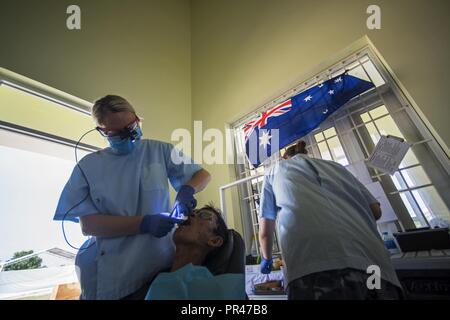 (À GAUCHE) Vol de la Royal Australian Air Force (RAAF) Lieutenant Jess Raine, dentiste RAAF RAAF travaille avec le Cpl. Hannah Fortington, un adjoint dentaire, d'effectuer une extraction de dent sur Luong Van Kiem au cours de Pacific Angel ANGEL (CIP) 18-2 à la Maison culturelle de Tam Giang située dans Nui Thanh, province de Quang Nam, Vietnam, le 12 septembre 2018. Cip ANGEL est une aide humanitaire multilatérale de l'engagement militaire civile, qui améliore de militaires à militaires dans l'Indo-Pacifique partenariats tout en fournissant des soins de santé, les projets d'ingénierie civile et l'objet d'échanges entre les partie Banque D'Images