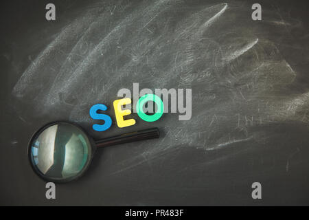 SEO Search engine optimization SEO de lettres couleur concept avec une loupe sur un fond noir Copyspace Banque D'Images