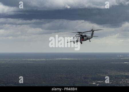 Un U.S. Air Force HH-60G Pave Hawk vole au-dessus de la ligne de côte de la Caroline du Sud après avoir décollé de Joint Base Charleston, S.C. participant à un vol de familiarisation, 16 septembre 2018. Ces vols offrent une tactique de la région et les équipes de préparation pour répondre à une mission de sauvetage en trente minutes ou moins lors de l'appel. Le 334e groupe expéditionnaire aérienne est une unité de recherche et de sauvetage expéditionnaire composé de 23d 920e Escadre et le personnel de l'Escadre de sauvetage des actifs et prêts à effectuer la surface, à voilure fixe et tournante des opérations de R-S en cas de besoin. Banque D'Images