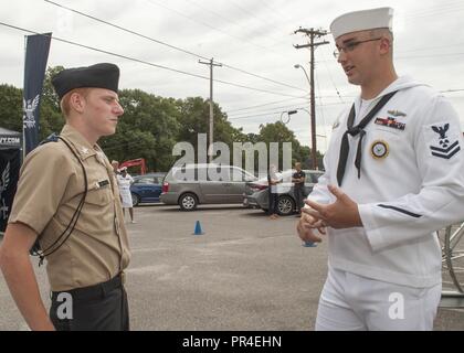 MILLINGTON, Tennessee (sept. 12, 2018) Machiniste Mate 2e classe Thomas Daily, un recruteur de la Marine affecté à la Force d'acquisition de talents, parle à Mid-South Dustin Bomes, membre de la formation des officiers subalternes de réserve, Corps au cours d'une visite prévue à l'Millington Area High School. Au cours de la visite les élèves ont eu l'occasion de l'expérience de la Marine, de l'actif de réalité virtuelle du "le Nimitz." L'expérience consiste en une série d'exercices, en commençant par un exposé, avant de participer à une grande vitesse virtuelle l'extraction de l'eau d'un Navy SEAL team c'est coincé sous le feu de l'ennemi. T Banque D'Images