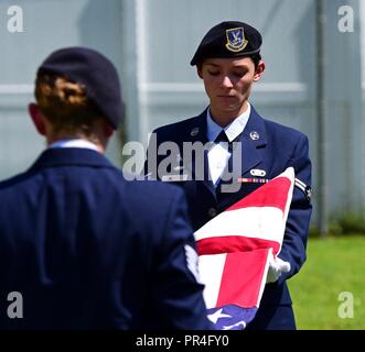 U.S. Air Force Michael Arleen Navigant de première classe, à droite, et le sergent. Katelyn Grau, gauche, 325e Escadron des Forces de sécurité d'aviateurs, plier le drapeau américain cérémonieusement en souvenir de chien de travail militaire (MWD) Jack durant son service commémoratif à la base aérienne Tyndall, en Floride, le 7 septembre 2018. Jack, un Malinois belge, était un chien de patrouille et d'explosifs qui ont partagé un lien spécial avec son maître. MWDs bénéficient des militaires et de courtoisie. Banque D'Images