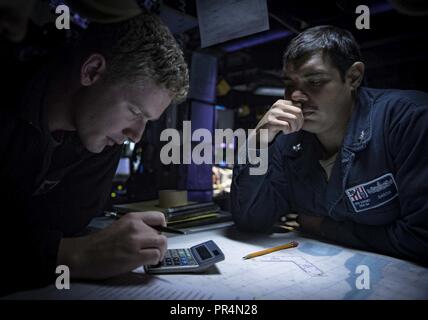 Mer (sept. 14, 2018) Spécialiste des opérations 1re classe Jacob Smith, à gauche, et spécialiste des opérations 2e classe Emmanuel Garcia se regarder dans le centre d'information de combat à bord de la classe Arleigh Burke destroyer lance-missiles USS Carney (DDG 64) Septembre 14, 2018. Carney, l'avant-déployé à Rota, en Espagne, est sur sa cinquième patrouille dans la sixième flotte américaine zone d'opérations à l'appui d'alliés et de partenaires régionaux ainsi que les intérêts de sécurité nationale des États-Unis en Europe et en Afrique. Banque D'Images