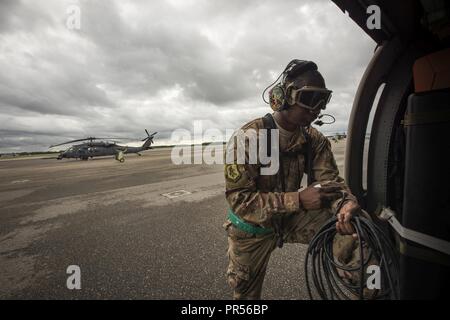 Un chef d'équipe affectée au 334e groupe expéditionnaire aérienne prépare un HH-60G Pave Hawk pour vol, 16 septembre 2018, à Joint Base Charleston, S.C. Le 334e AEG est une force expéditionnaire de l'unité de recherche et de sauvetage qui est pré-positionné pour fournir des secours dans la foulée de la tempête tropicale Florence. Composé de 23d 920e Escadre et le personnel de l'Escadre de sauvetage et d'actifs, la 334e AEG est prête pour l'exécution de surface, à voilure fixe et tournante des opérations de R-S en cas de besoin. Banque D'Images