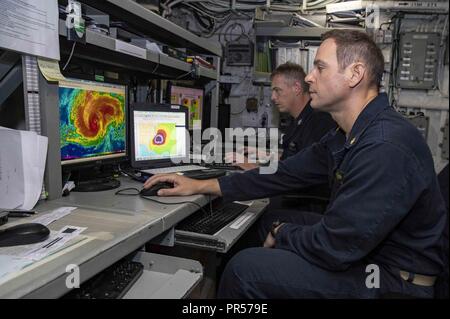 Océan Atlantique (septembre 1994). 13, 2018) Le lieutenant Cmdr. Tchad Geis, droite, de météorologie et d'océanographie et d'Aérographe, agent de 1ère classe 4400 Russell Ligon analyser l'ouragan Florence dans la chambre météorologique à bord de la classe Wasp-navire d'assaut amphibie USS Kearsarge (DG 3). Le Commandement du Nord des Forces navales des États-Unis déployée, avec Kearsarge éléments embarqués de la 22e unité expéditionnaire de marines et le groupe expéditionnaire 2 Élément de commandement, d'être en mesure de fournir l'appui de la défense aux autorités civiles de la mer à la suite de l'ouragan Florence, devraient soutenir être demandée. Banque D'Images