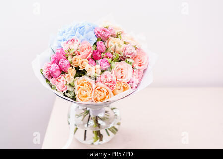 Beau bouquet de fleurs de printemps. arrangement avec différentes couleurs de vase en verre rose sur table. Cette chambre lumineuse, mur blanc. copy space Banque D'Images