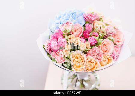 Beau bouquet de fleurs de printemps. arrangement avec différentes couleurs de vase en verre rose sur table. Cette chambre lumineuse, mur blanc. copy space Banque D'Images