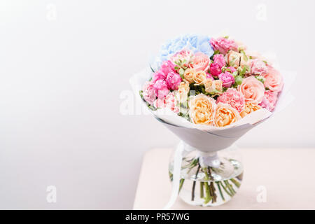 Beau bouquet de fleurs de printemps. arrangement avec différentes couleurs de vase en verre rose sur table. Cette chambre lumineuse, mur blanc. copy space Banque D'Images