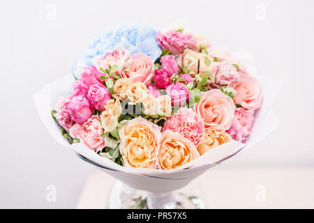 Beau bouquet de fleurs de printemps. arrangement avec différentes couleurs de vase en verre rose sur table. Cette chambre lumineuse, mur blanc. Banque D'Images