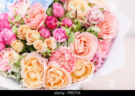 Beau bouquet de fleurs de printemps. arrangement avec différentes couleurs de vase en verre rose sur table. Cette chambre lumineuse, mur blanc. Banque D'Images