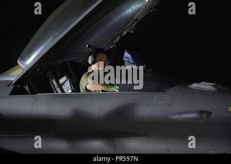 L'entretien d'un membre est affecté à la 157e Escadron de chasse expéditionnaire effectue des contrôles de fonctionnement dans le cockpit d'un F-16 Fighting Falcon après l'atterrissage dans un endroit inconnu en Asie du Sud-Ouest, le 13 septembre 2018. Dans le cadre de l'US Air Forces Central Command, le 407e groupe expéditionnaire de la combat fournit à l'appui de l'U.S. Central Command des objectifs militaires. AFCENT emploie l'ensemble du spectre des capacités de la composante aérienne dans l'air, l'espace et le cyberespace pour vaincre les ennemis tout en favorisant la sécurité et la stabilité dans la région. Les États-Unis est postured pour défendre les forces américaines dans la région f Banque D'Images