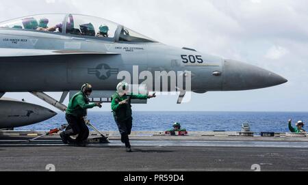 Mer des Philippines (18 septembre 2018) l'Aviation Boatswain's Mates (Matériel) 3 Classe Jordanie Barrett, gauche, de Southbend, Indiana, et Hailey Barela, de Rio Rancho, Nouveau Mexique, effacer la zone de lancement en tant qu'EA-18G Growler affectés à l'Escadron d'attaque électronique (VAQ) 141 se prépare à lancer à partir de la cabine de pilotage de la Marine a déployé des porte-avions USS Ronald Reagan (CVN 76) au cours de Valiant Shield en 2018. La biennale, uniquement aux États-Unis, l'exercice d'entraînement sur le terrain se concentre sur l'intégration de la formation conjointe entre l'US Navy, l'armée de l'Air et Marine Corps. C'est la septième de l'exercice dans le vaillant Banque D'Images