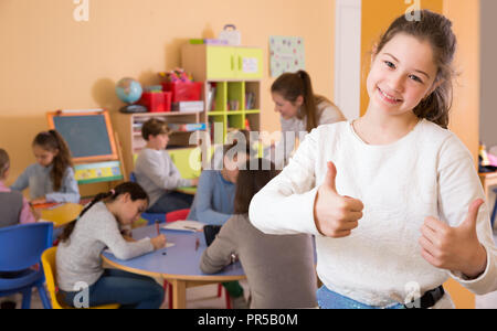 Portrait of smiling schoolgirl et les enfants en classe de dessin Banque D'Images