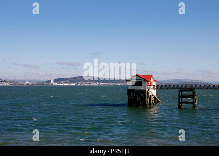 L'ancienne station de sauvetage de la RNLI, avec Swansea City dans l'arrière-plan, Mumbles, Swansea, Pays de Galles, Royaume-Uni Banque D'Images