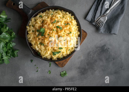 Mac et fromage, american style macaroni pâtes avec sauce au fromage et chapelure croquante topping sur table béton, copie espace Vue de dessus Banque D'Images