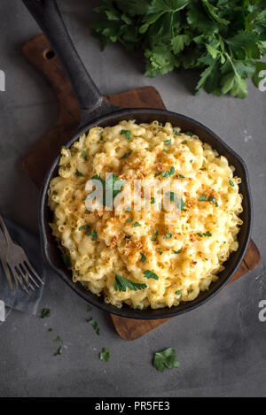 Mac et fromage, american style macaroni pâtes avec sauce au fromage et chapelure croquante topping sur table béton, copie espace Vue de dessus Banque D'Images