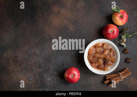 Confiture de pommes maison (apple chutney, confiture, sauce chunky) avec de la cannelle, l'anis et les pommes sur fond rustique, vue du dessus. Banque D'Images