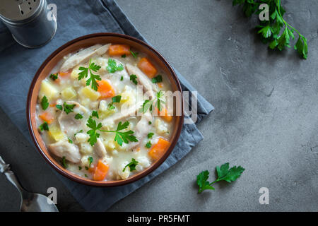 Soupe Poulet et riz sauvage. Frais fait maison soupe crémeuse au poulet, légumes et riz sauvage dans un bol blanc, vue du dessus. Banque D'Images