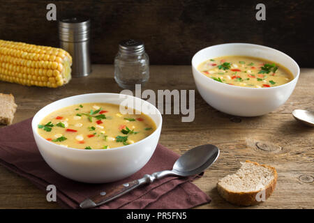 Chaudrée de maïs maison soupe dans un bol blanc. Soupe de maïs crémeux végétarien avec les verts et les légumes. Banque D'Images