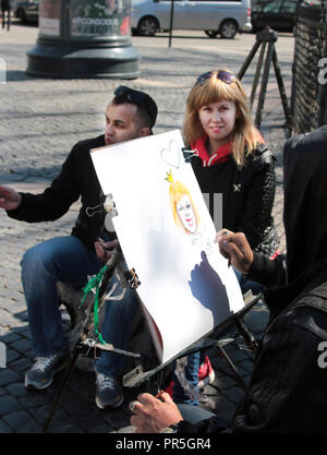 Une femme est posant pour un portrait plutôt louche à être dessiné par un artiste de rue à St Petersbourg en Russie. Banque D'Images