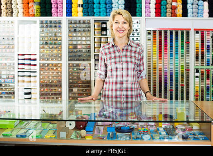 Portrait of mature plaisir féminin européen permanent de caissier à la caisse et dans la broderie shop Banque D'Images