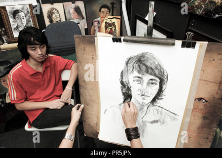 Le jeune homme est assis pour le portrait-artiste dans le marché central, Chinatown, Kuala Lumpur, Malaisie Banque D'Images