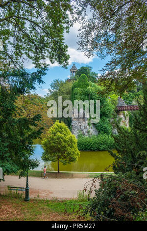 Paris, France - le 8 août 2018 : homme marchant le long d'un chemin au parc (Parc des Buttes-Chaumont) à Paris un jour d'été. Banque D'Images