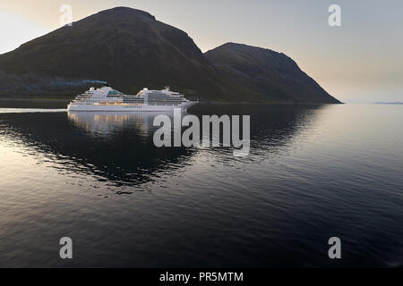 Le bateau de croisière, Seabourn Ovation, traverse le Lauksundet, près de Skjervøy, loin au nord du cercle arctique norvégien pendant le soleil de minuit. Banque D'Images