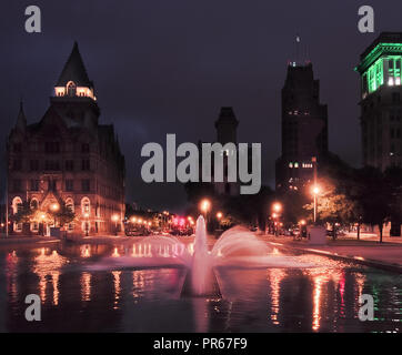 Syracuse, New York, USA. Le 29 septembre 2018. Clinton Square, au centre-ville de Syracuse, NY, avec fontaine et bassin réfléchissant à la nuit Banque D'Images