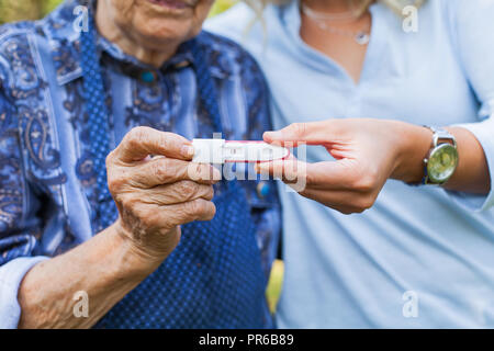 Photo Close up of young woman holding test de grossesse avec grand-mère. Arrière-petits sur le chemin Banque D'Images