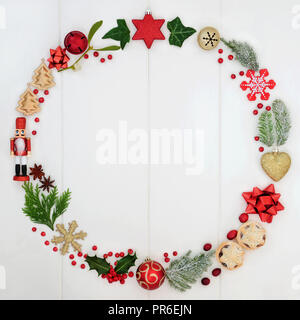 Abstract Christmas wreath garland avec une sélection de symboles traditionnels, y compris la nourriture, de la flore et de décorations babiole sur fond de bois blanc rustique Banque D'Images