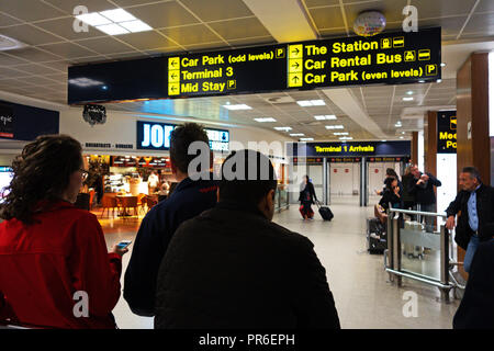 Les personnes en attente de personnes dans le hall des arrivées à l'Aéroport International de Manchester, Royaume-Uni Banque D'Images