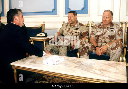 Charles Freeman, ambassadeur des États-Unis en Arabie Saoudite, s'entretient avec le président de l'état-major des armées Le Général Colin Powell et le général H. Norman Schwarzkopf, commandant en chef, le Commandement central américain. Les hommes prennent part à une réunion au sujet de la coalition des forces alliées au cours de l'opération Bouclier du désert. Banque D'Images