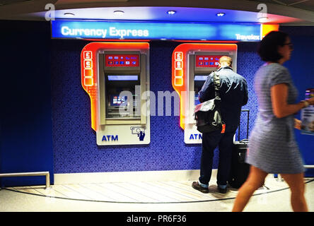 L'homme en utilisant le Hall d'arrivée au distributeur à l'aéroport de Manchester, Royaume-Uni Banque D'Images