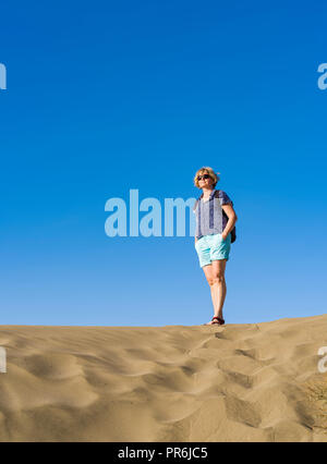 Femme d'âge moyen debout sur les dunes de Maspalomas Banque D'Images