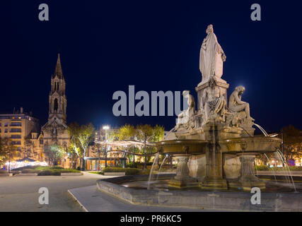 Fontaine Pradier allumé à la tombée de la vieille ville de Nimes en France Banque D'Images